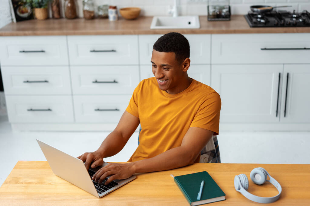 stock-photo-portrait-smiling-african-american-man-freelancer-copywriter-typing-keyboard-wearing